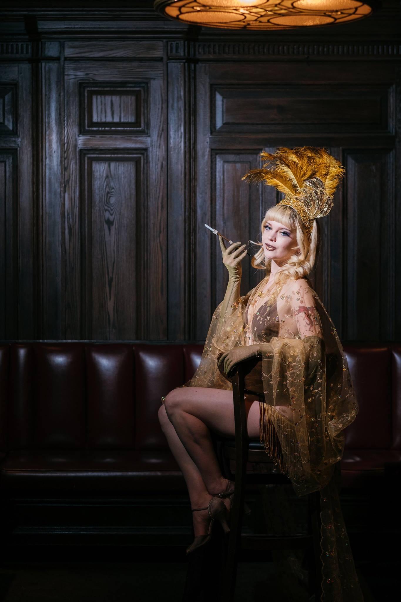 Image of a woman in vintage nightgown, smoking a cigarette in a dark, wood-paneled room